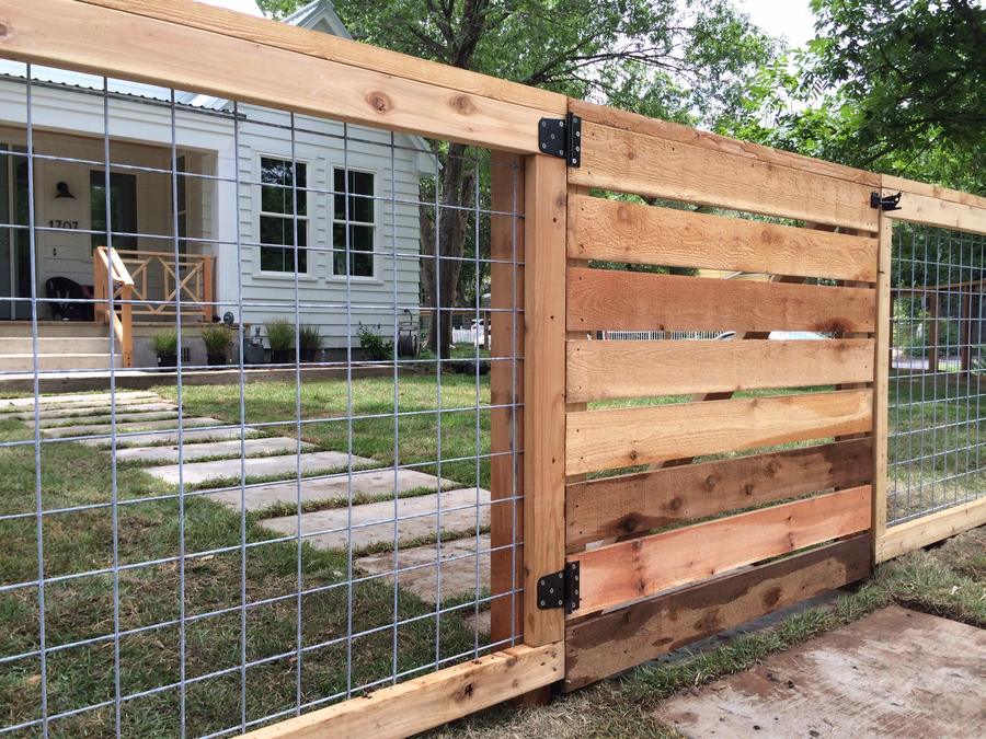 Modern horizontal cedar fence with wire mesh panels at a white house