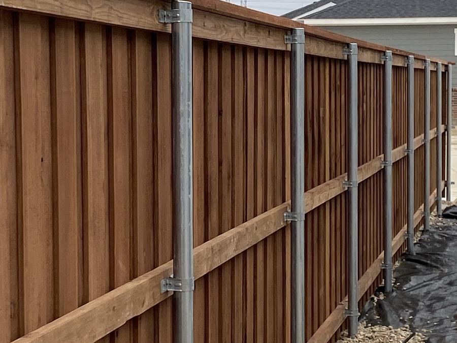 Tall cedar screen wall built on galvanized steel posts