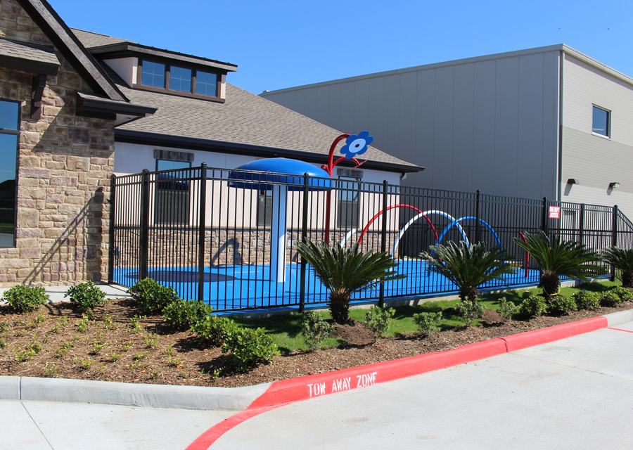Ornamental iron fence enclosing a private school play area